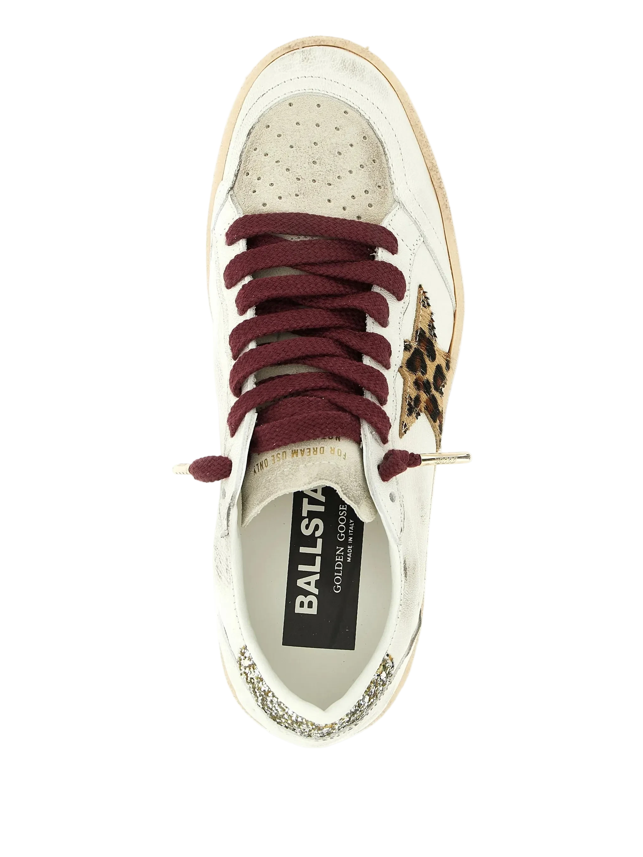 White sneaker with maroon laces and leopard print accents on a white background